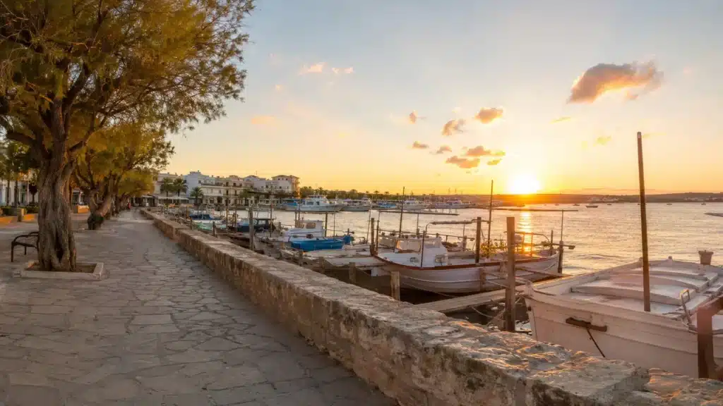 Küstenpromenade und Fischerboote in Colònia de Sant Jordi bei Sonnenuntergang